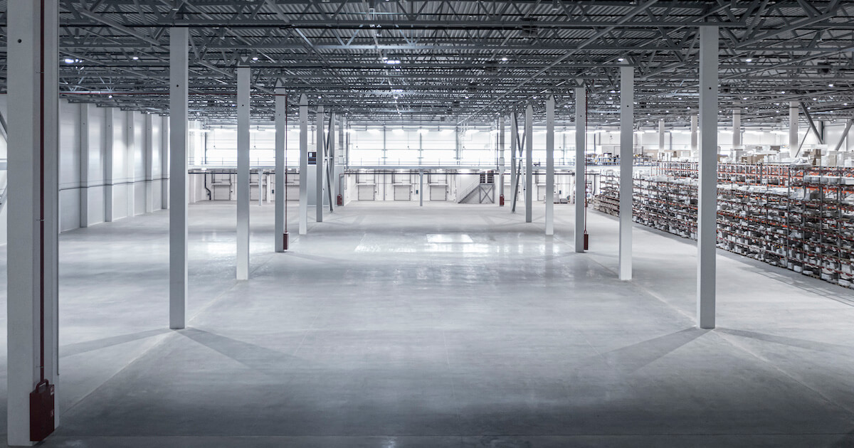 The concrete floor inside an empty section of a manufacturing facility.
