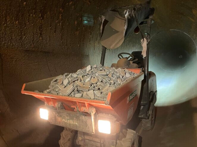 A small motorized carrier hauling a load of broken mortar pieces out of the Etiwanda Pipeline in Southern California.