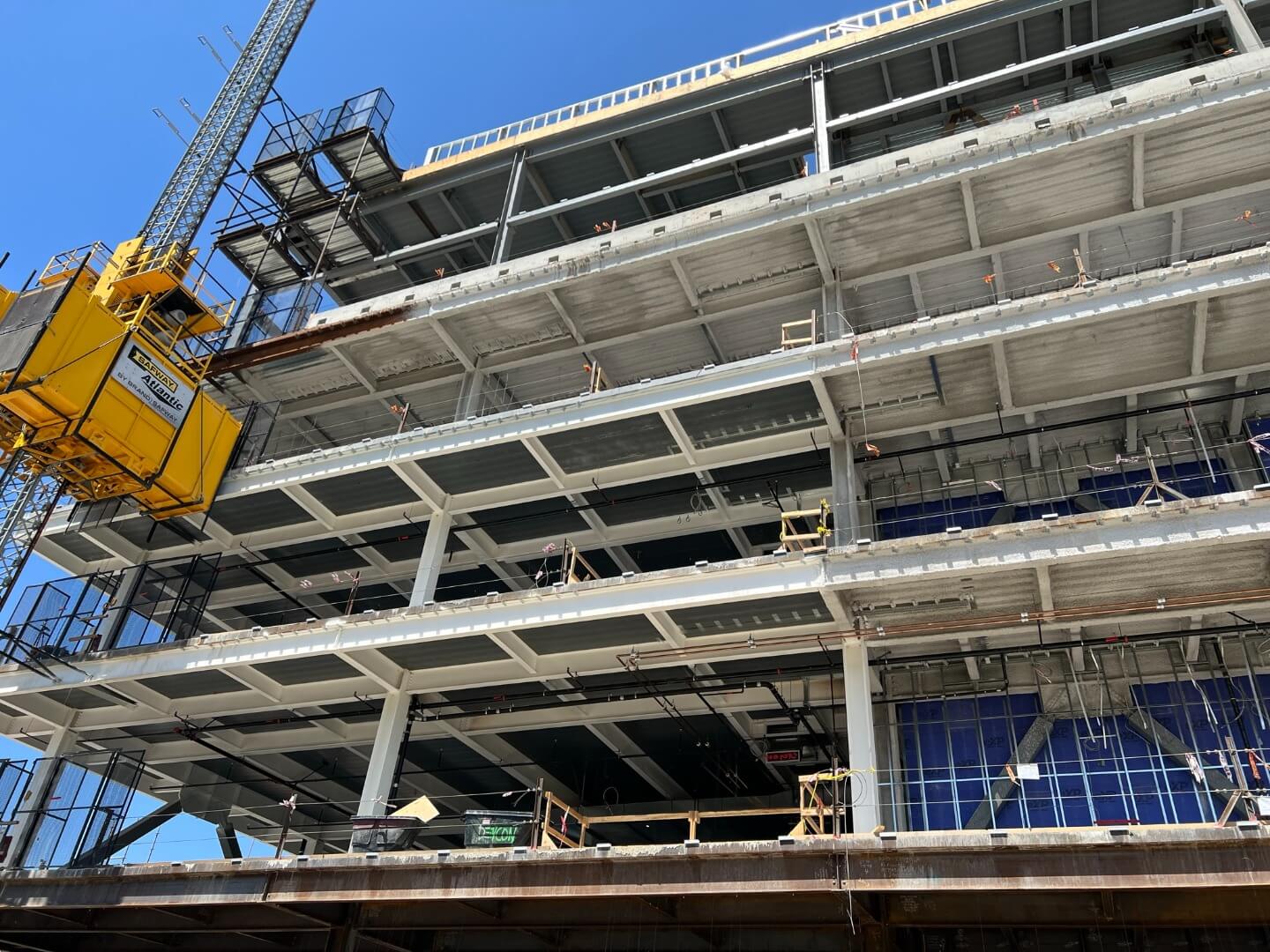 A wide shot view of multi-story steel commercial building during open frame construction.