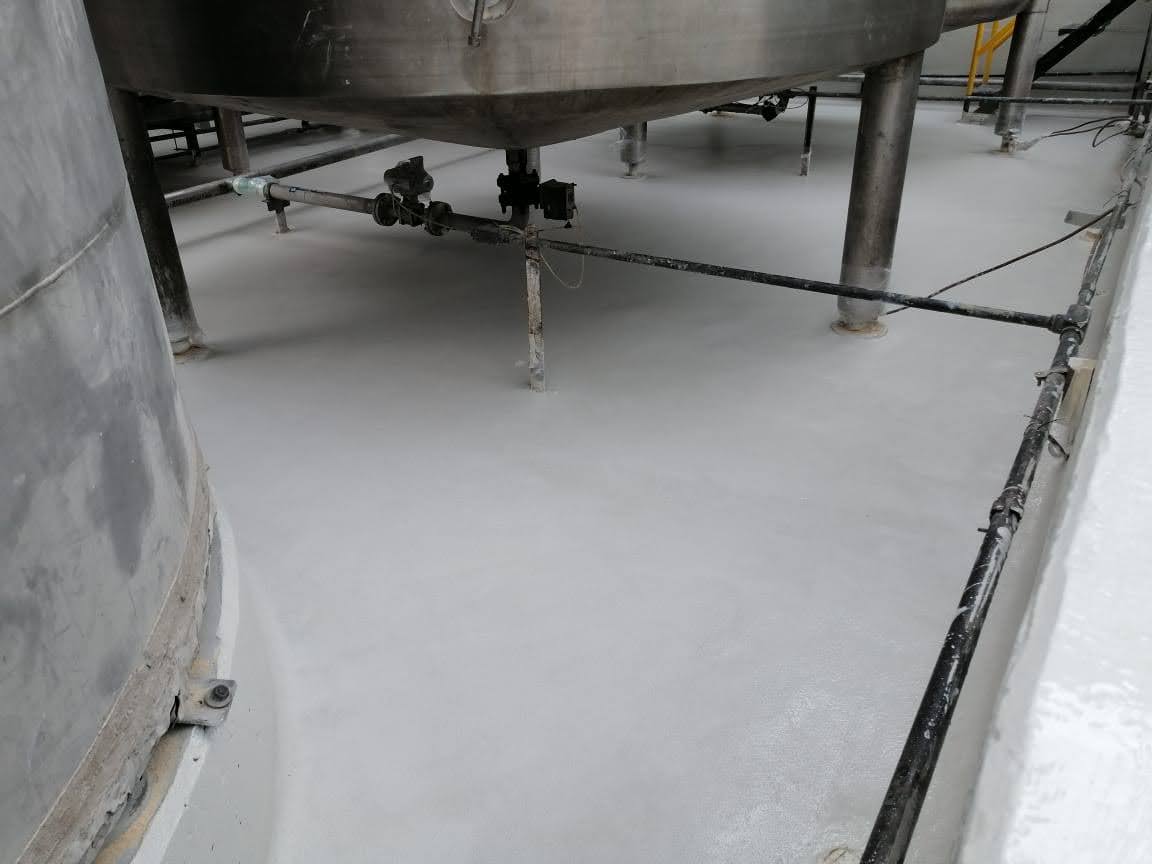 hemical-resistant floor coating protecting a concrete secondary containment area beneath process equipment.