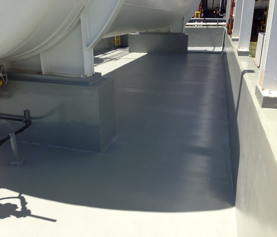 Coated concrete secondary containment area surrounding an aboveground horizontal storage tank at an industrial processing facility.